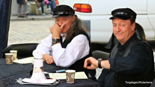 Bjørn Jensen og Tor Endresen skriv autografar og Endresen ser på klokka... Litt kort tid til lydprøver gjer at dei kjem litt for seint på scena